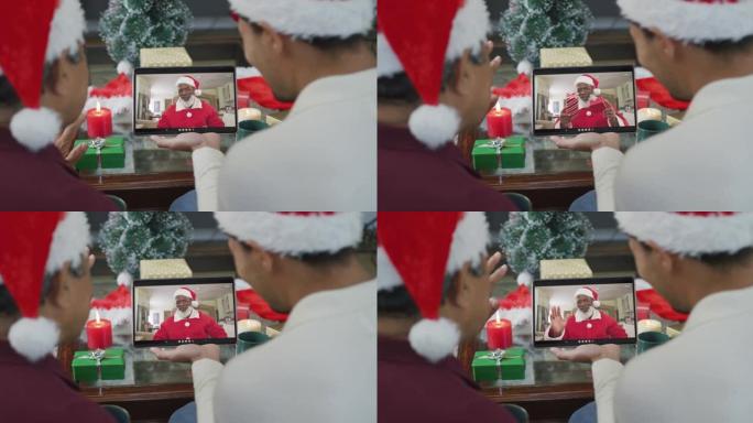 混血儿父子挥舞并使用平板电脑与屏幕上的圣诞老人进行圣诞节视频通话