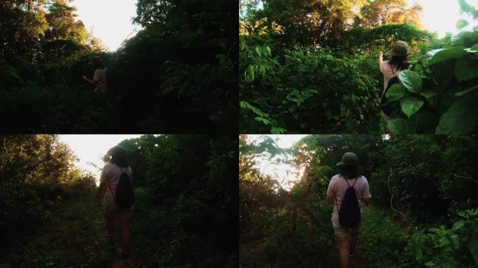 女旅行者在丛林热带森林的小径上徒步旅行，到日落黄昏，到假日度假的山崖