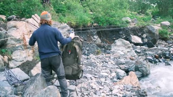 游客用登山带固定背包，以穿越崎mountain的山河。