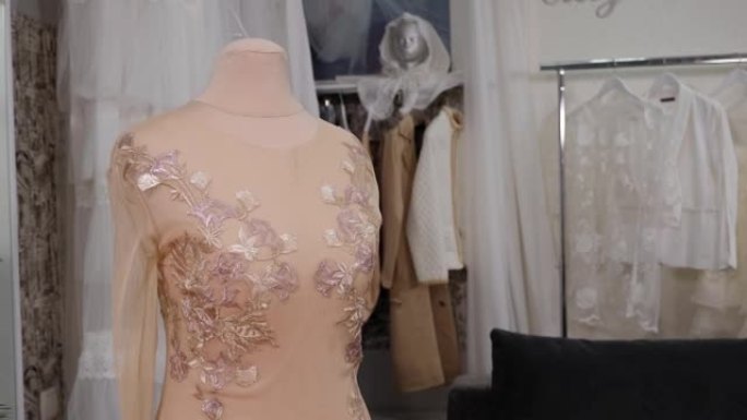 工作室中人体模型上美丽的米色镂空连衣裙的特写镜头。