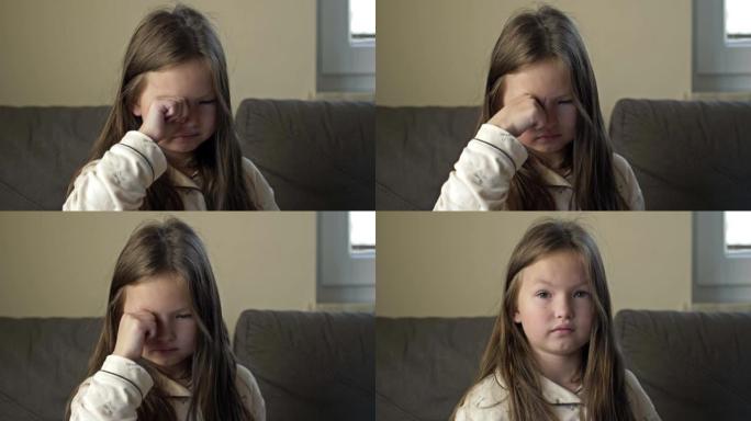 一个刚醒来的6-7岁女孩擦了擦眼睛