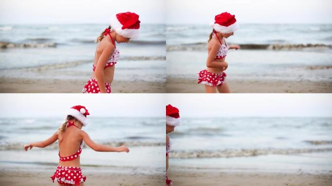 穿着红色泳衣和圣诞老人帽子的5岁女孩在海滩上快乐，跳舞，跳跃和奔跑快乐。圣诞节和新年冬季温暖国家之旅