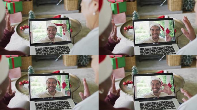 资深女性朋友使用笔记本电脑进行圣诞节视频通话，屏幕上有微笑的朋友