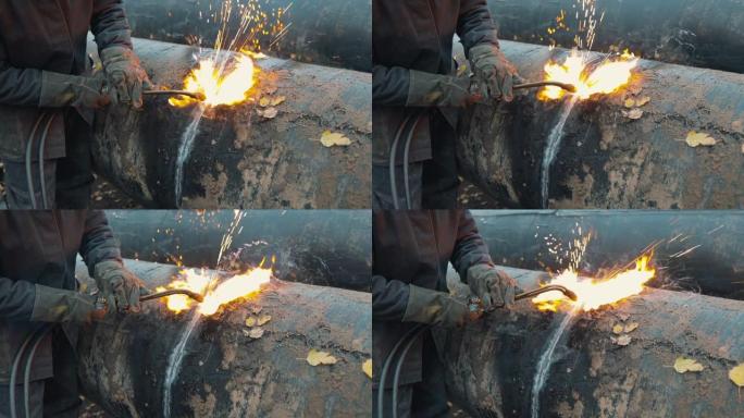 焊工用乙炔焊接切割大管进行气化。旧金属管道的处理