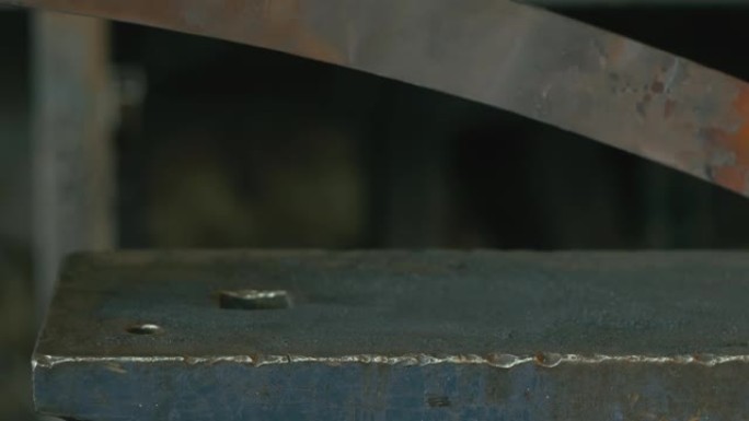 锻造车间。史密斯手工制作。史密斯用锤子的手击中了炽热的金属，铁砧上的锻造过程。