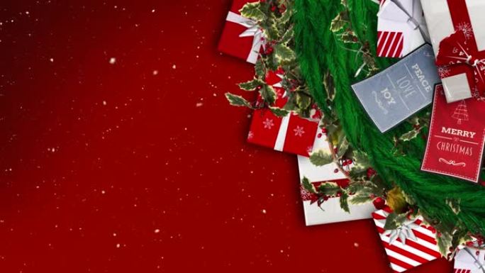 雪落在红色背景下的圣诞花环装饰品、卡片和礼物上