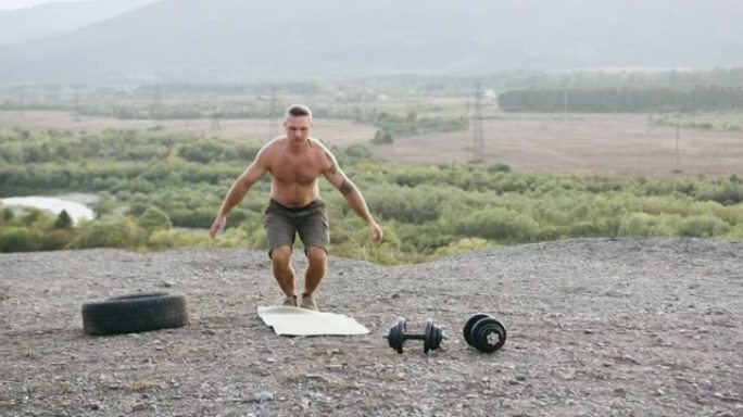英俊自信的运动强壮的赤膊男人的前视图，在夏天的早晨，在独特美丽的自然背景下，在石山上做俯卧撑和跳跃