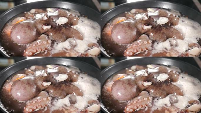 将章鱼在锅中煮沸，并在黑色背景上升起蒸汽。餐厅厨房里的海鲜烹饪。美味的大章鱼在煎锅里煮沸。水沸腾。章