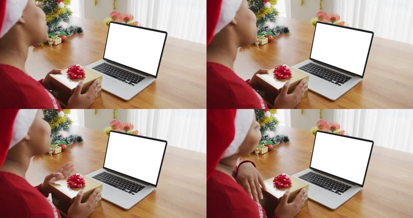 戴着圣诞老人帽子的非洲裔美国妇女进行笔记本电脑圣诞节视频通话，屏幕上有复制空间