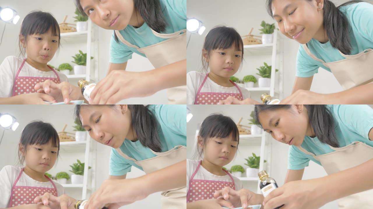 亚洲儿童在家里一起烘焙饼干之前，测量香草提取物的准备，生活方式的概念。