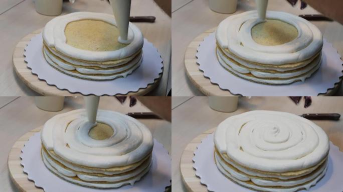 在多层蛋糕中的海绵蛋糕上涂一层厚厚的奶油