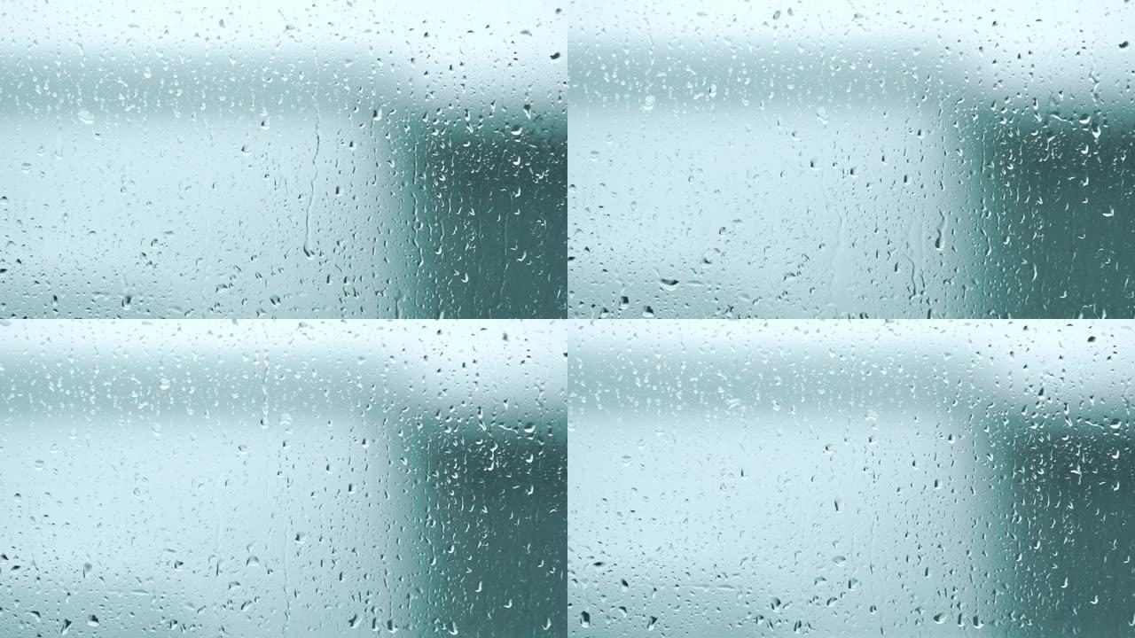 雨水形成的水滴流入窗户上的玻璃。4k，慢动作。