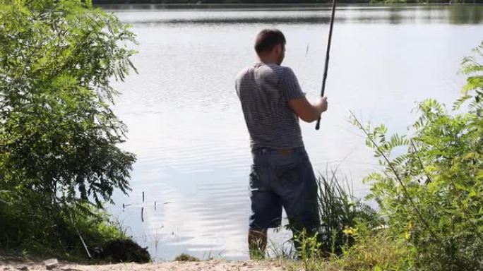 带鱼竿的渔夫。活动和爱好。钓鱼淡水湖池塘河。
