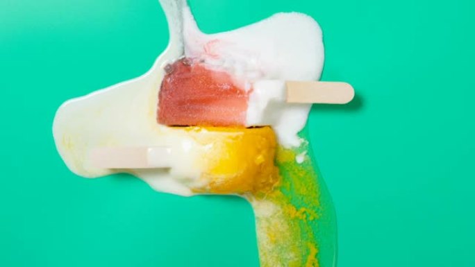 顶视图芒果味冰棒和桃子味融化在绿色背景上的时光倒流