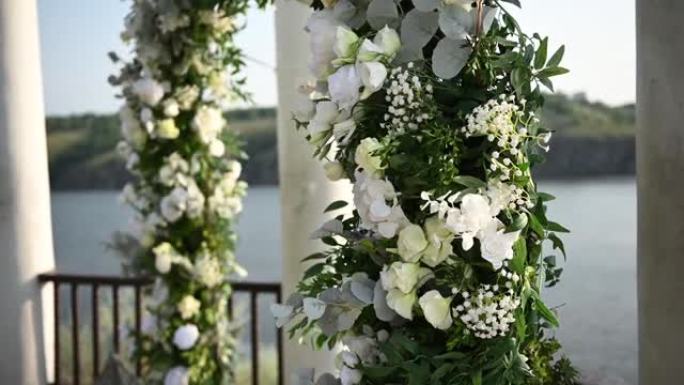 优雅的婚礼拱门，鲜花，河流背景上的花瓶