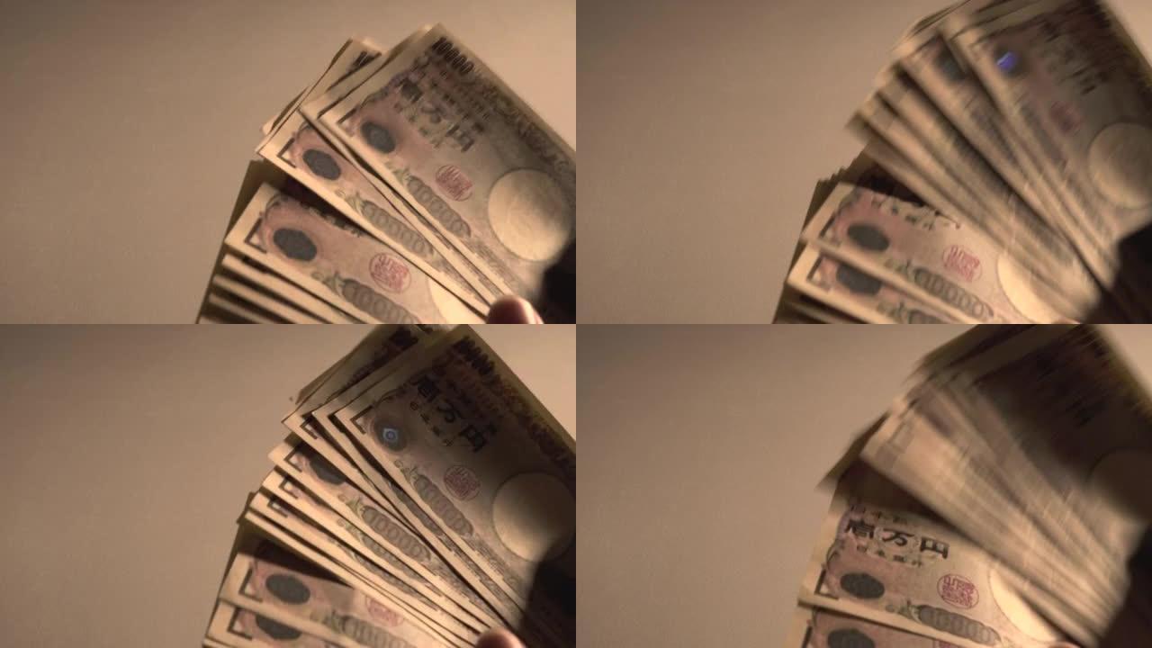 享受手中现金的男人。男人数日元钞票。