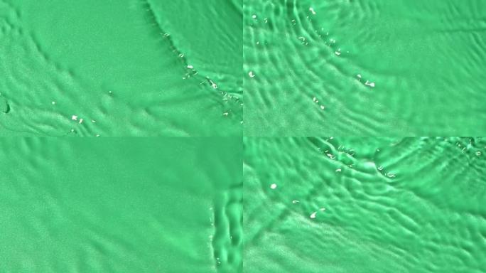 慢动作水面纹理飞溅，波纹在绿色背景上隔离