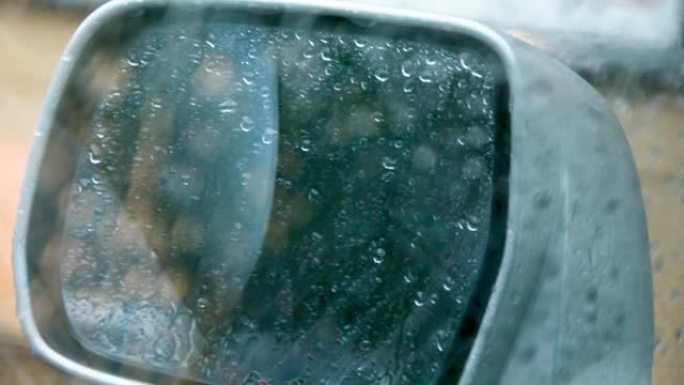 雨中汽车的侧后视镜，雨滴在侧镜和车窗上