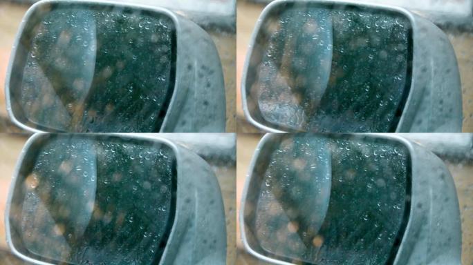 雨中汽车的侧后视镜，雨滴在侧镜和车窗上