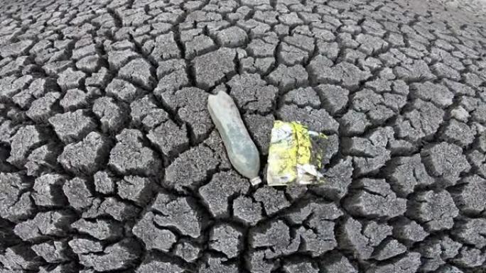 干燥的湖床上的塑料废物，破裂的地球