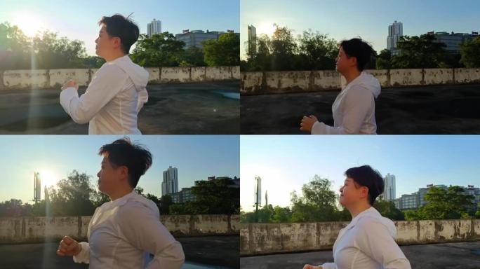 侧视图亚洲中国中年妇女，穿着运动运动服，早上在屋顶停车场跑步
