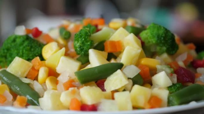 新鲜混合蔬菜青豆玉米西兰花红辣椒胡萝卜在盘子特写。宏观拍摄混合蔬菜背景。健康清洁饮食，有机节食素食素