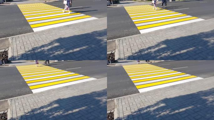 4k视频，两个行人过马路上新的人行横道黄白标记，生命安全，运输概念