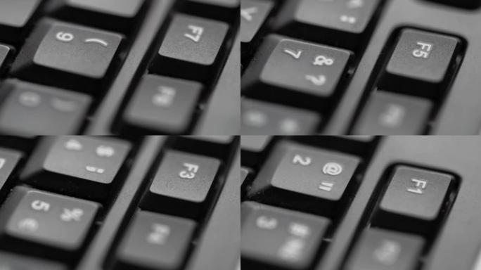 黑色背景上的黑色电脑键盘特写。按键上的慢动作。低景深。黑暗计算机互联网技术背景。业务按钮沟通。
