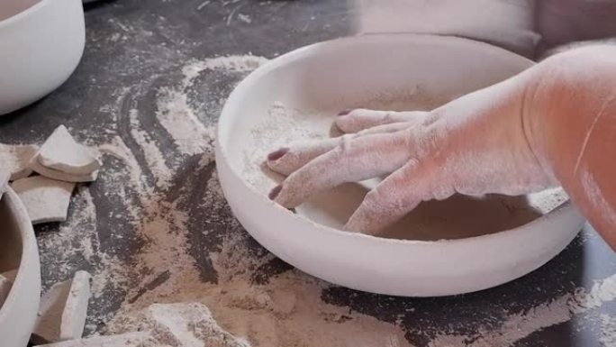 女陶瓷艺术家正在打磨生陶瓷碗。