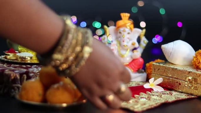 已婚女孩戴着手镯，在印度教神领主甘尼萨·甘帕蒂·巴帕·莫里亚面前深深地敬拜新年迪帕瓦里