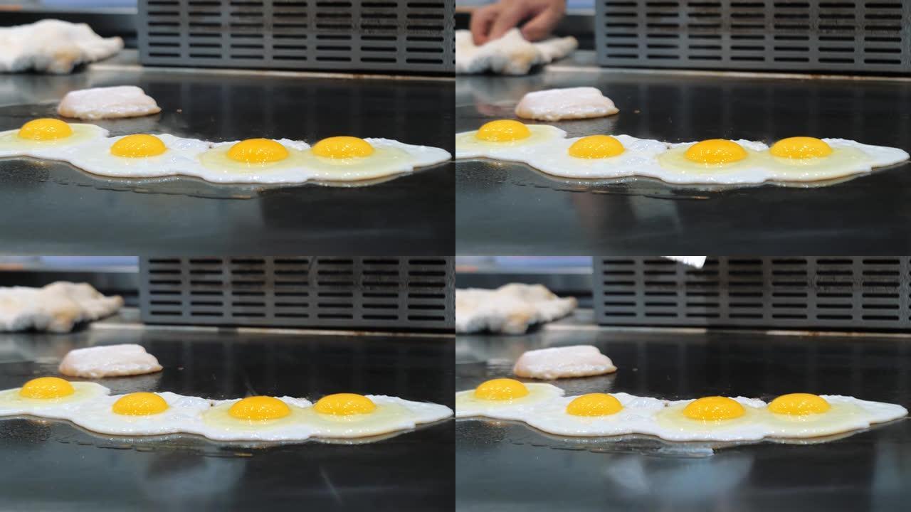 煎炸面板上的鸡蛋。在油炸面板上油炸碎鸡蛋的特写镜头。炒鸡蛋烹饪。