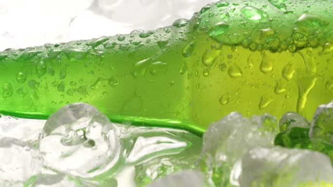 啤酒瓶在冰块上冷却，侧视图，玻璃上的水滴，带飞溅的清爽冷冻酒精饮料