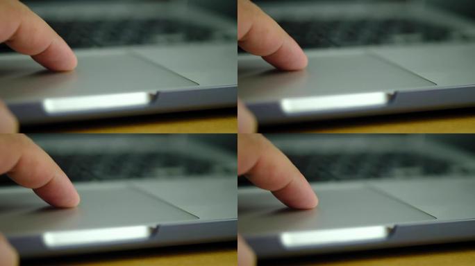 男士手指在工作时使用笔记本电脑触摸板的特写慢动作，使用电脑