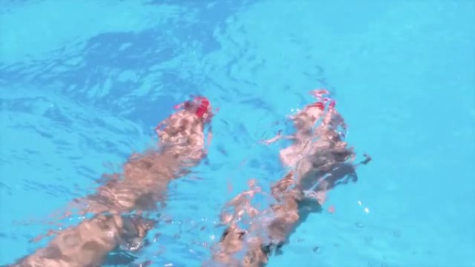 带有红色指甲油的雌性脚在水中移动，飞溅