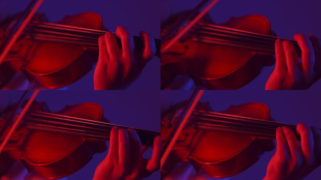 小提琴家女人在红光工作室用手指和琴弦演奏，特写镜头。交响音乐的概念
