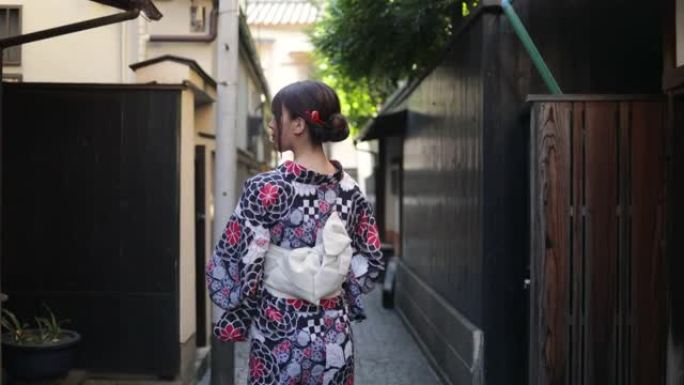 日式浴衣的日本妇女走在狭窄的道路上 -- 后视图和抬头看