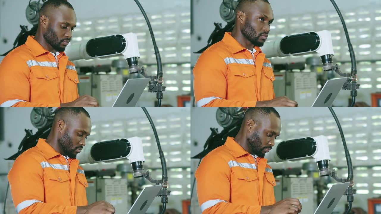 非裔美国人在工厂工作控制自动化机器人。