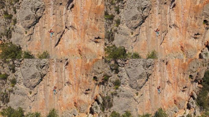 无人机的航拍画面。无人机从石灰岩悬崖上飞出，上面装有攀岩者。男子在垂直岩顶上攀登具有挑战性的路线