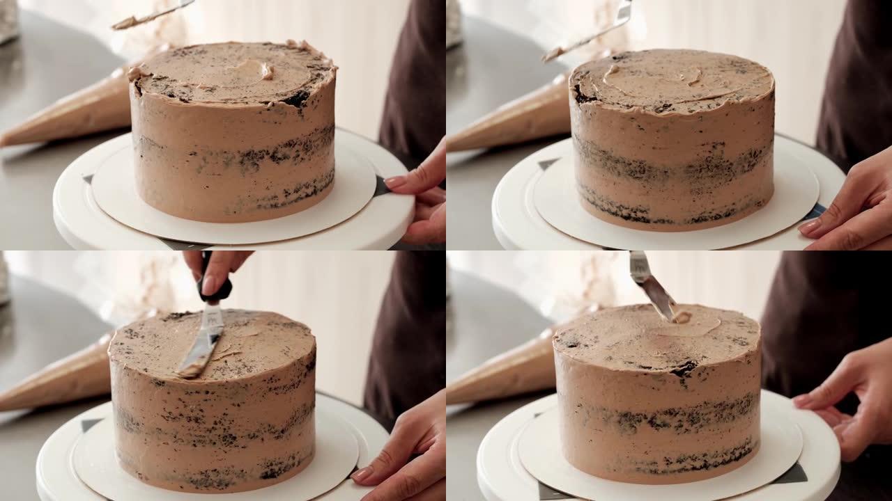 4k女糕点厨师在巧克力蛋糕上抚平巧克力奶油，特写镜头。慢动作。蛋糕制作过程。