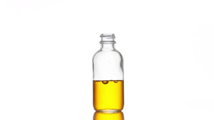维生素c落入带有黄色液体的医疗瓶中