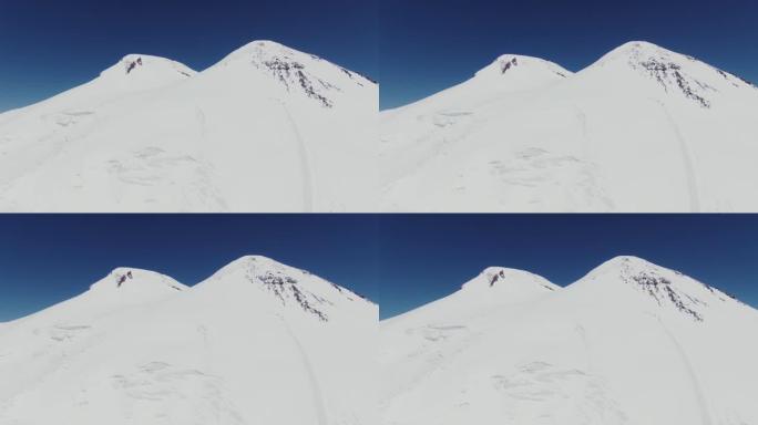 埃尔布鲁斯山白雪覆盖的岩石峰。带滑雪道的雪坡