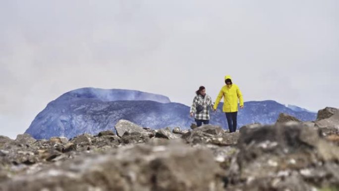 游客走开，并在背景中欣赏火山爆发的壮丽景色