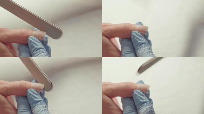 使用特殊机器在美甲沙龙中去除女性指甲上的清漆的过程。