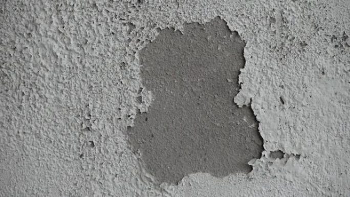 白色潮湿的墙壁显示油漆开裂，破裂或剥落。墙壁上脆弱的白色衬里。抽象的破裂和肿胀的黑白背景。宏特写视图