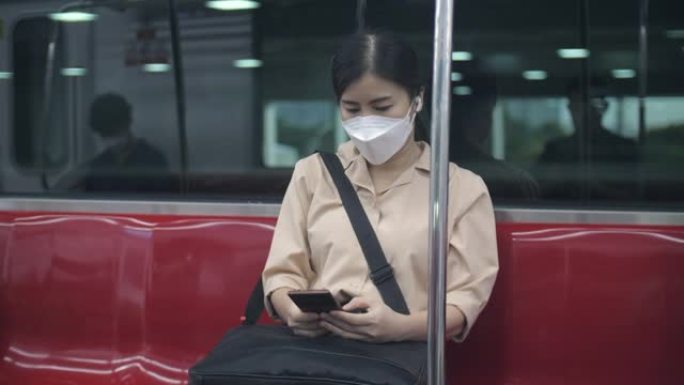 年轻女子戴着无线耳机，在火车上旅行时做工作