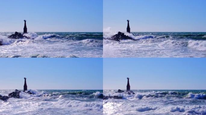 海上风暴。波浪拍打着古老的灯塔和岩石，形成飞溅和泡沫。