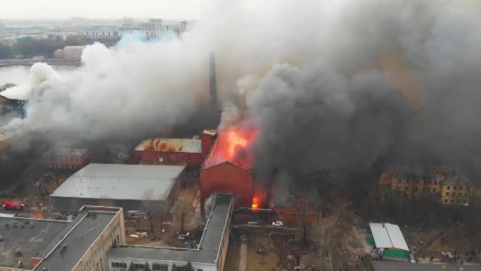 城市发生大规模大火，空中无人机俯视图砖厂大楼着火，地狱火爆炸火焰爆炸，有消防员队伍，纵火，烧毁破坏