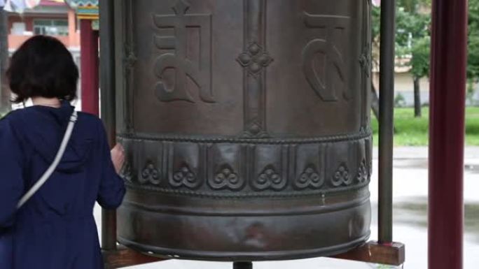 在达桑的佛寺里，一位微笑的黑发女郎摇着鼓，念着咒语