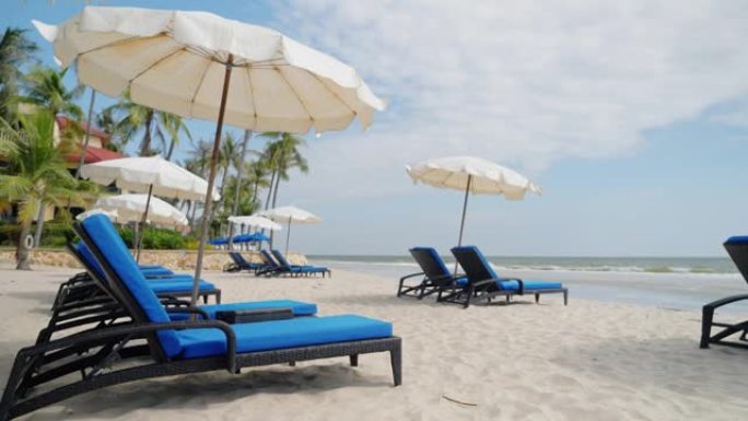 泰国华欣白色沙滩上的遮阳伞沙滩椅。
