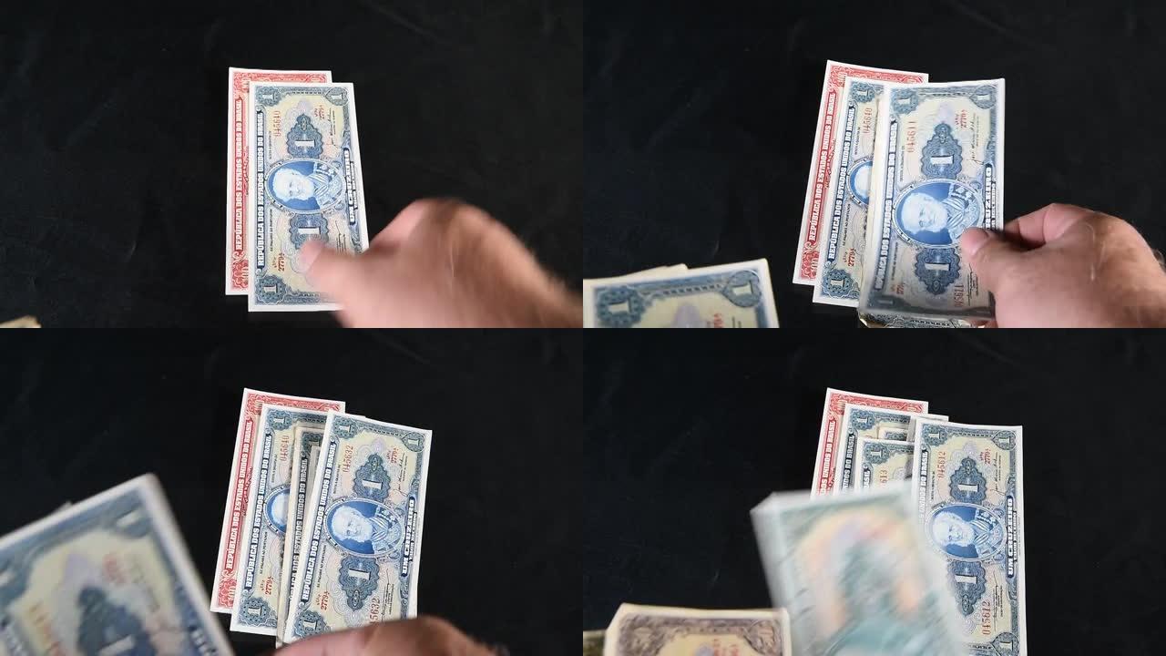 黑色背景上的旧巴西钞票落在桌子上。